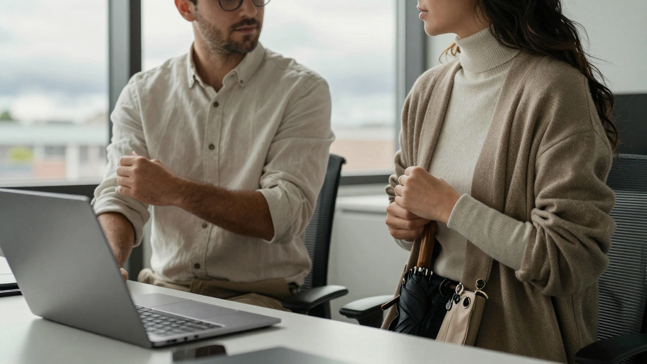 Two professionals in a Galway office wearing breathable linen and cardigans, working at a desk with an umbrella nearby under soft daylight.