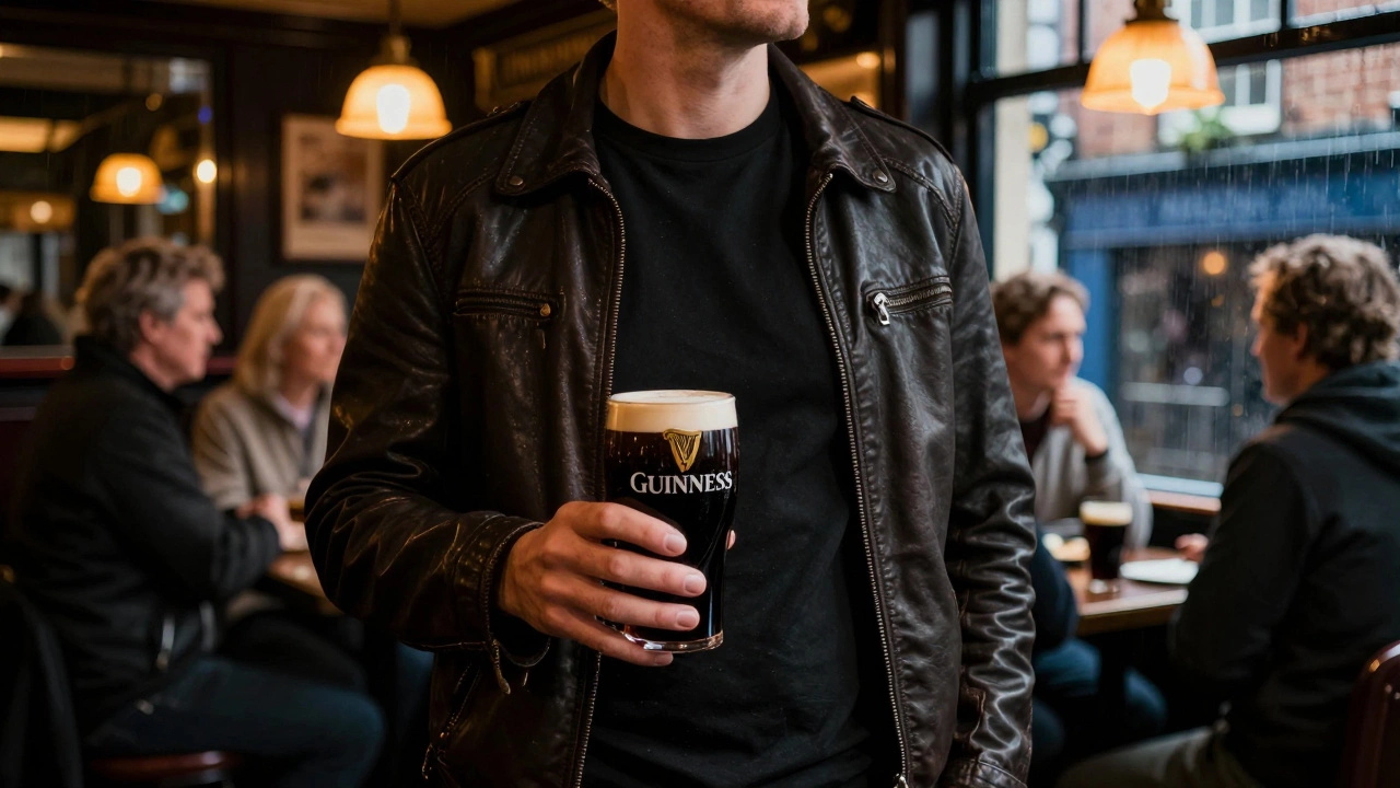 Person in a black t-shirt and leather jacket enjoying a drink in a dimly lit Irish pub
